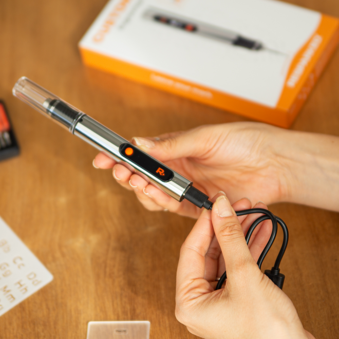 Holding the Customizer engraving pen with its packaging